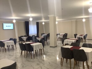 A conference room with multiple tables and chairs, a screen displaying 'SUNNY', and a large window with curtains. - Atlihan Plus Hotel (Dogubayazit)