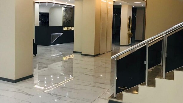 A modern lobby with a marble floor, a reception desk, and a staircase. - Atlihan Plus Hotel (Dogubayazit)