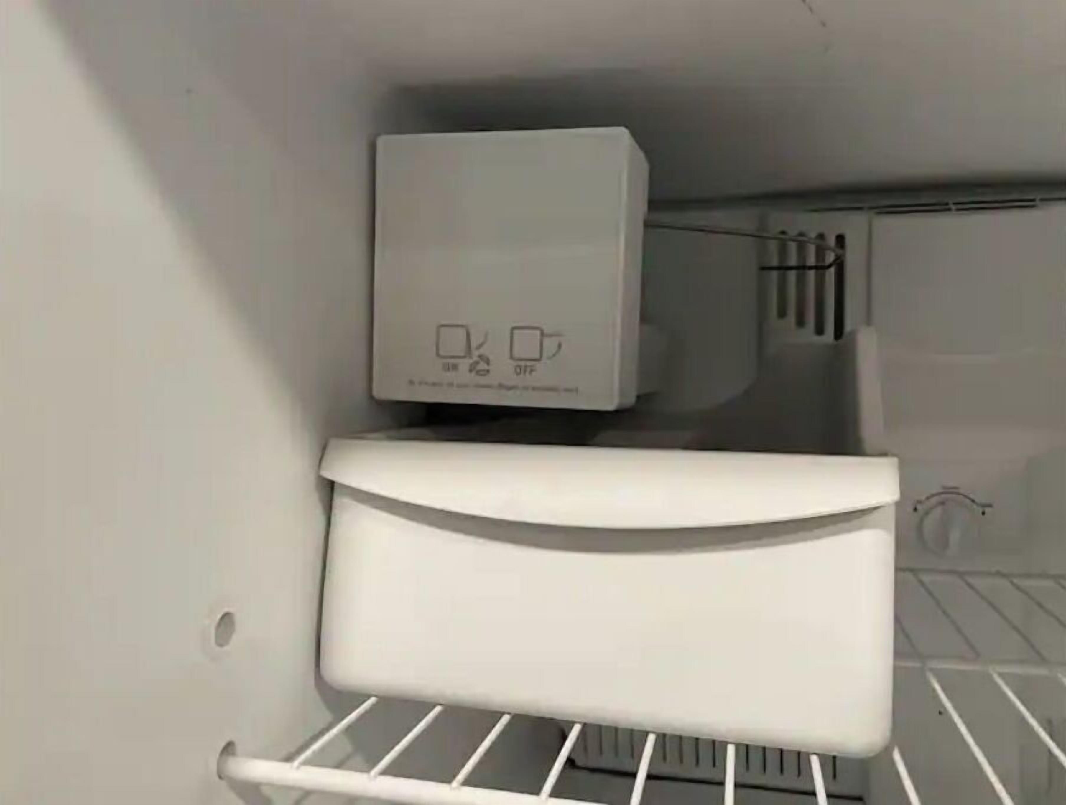 A white refrigerator with a control panel displaying symbols for power and temperature settings.