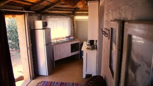 A compact kitchen with a refrigerator, microwave, sink, and a small countertop. - Perdehoek Venue (Lichtenburg)