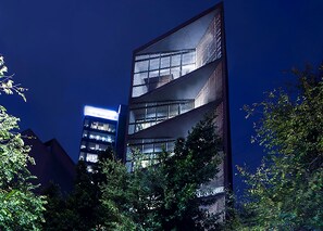 Un bâtiment moderne doté d’une façade en verre et de nombreux balcons.