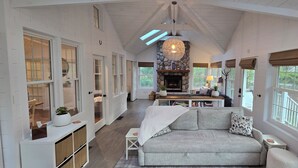A cozy interior with a fireplace, a sofa, and a dining area. - Relaxing Woodsy Cottage Retreat: Perfect for Families & Friends [Sleeps 8] (Michigan City)