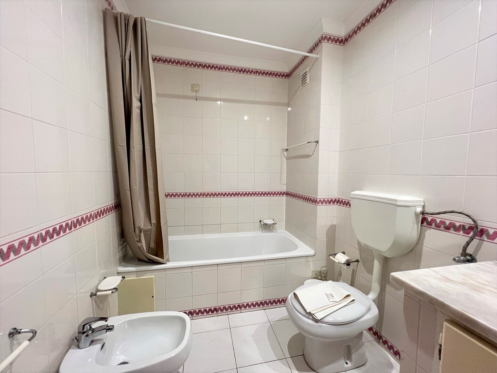 A bathroom with a bathtub, toilet, and sink.