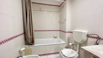 A bathroom with a bathtub, toilet, and sink.