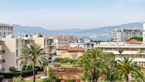 Una zona residencial costera con edificios de varios pisos, algunos con balcones, y palmeras al frente.