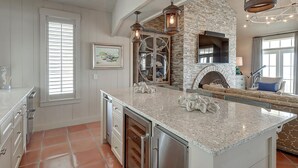 Un'ampia cucina con un'isola grande, una parete decorativa in pietra e un camino.