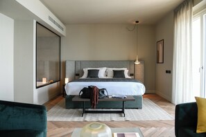 Ein modernes Hotelzimmer mit einem großen Bett, einem Nachttisch und Blick ins Freie.