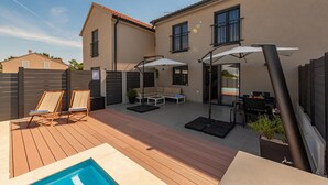 A backyard with a pool, lounge chairs, a barbecue area, and a covered seating area. - Villa NiA Zadarvillas (Nin)