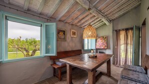 Un comedor rústico con una mesa de madera, un banco y una lámpara colgante.