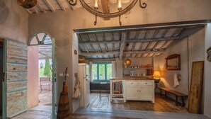 Cocina rústica con una isla de madera, un banco y vistas al exterior.