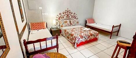 Una camera da letto con un letto, una sedia, un tavolo e uno specchio.