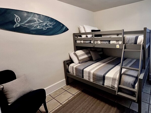 A bunk bed room with a striped bedspread, a chair, and a wall decoration. - 6 Blocks to the beach - beach bungalow style apartment (Virginia Beach)