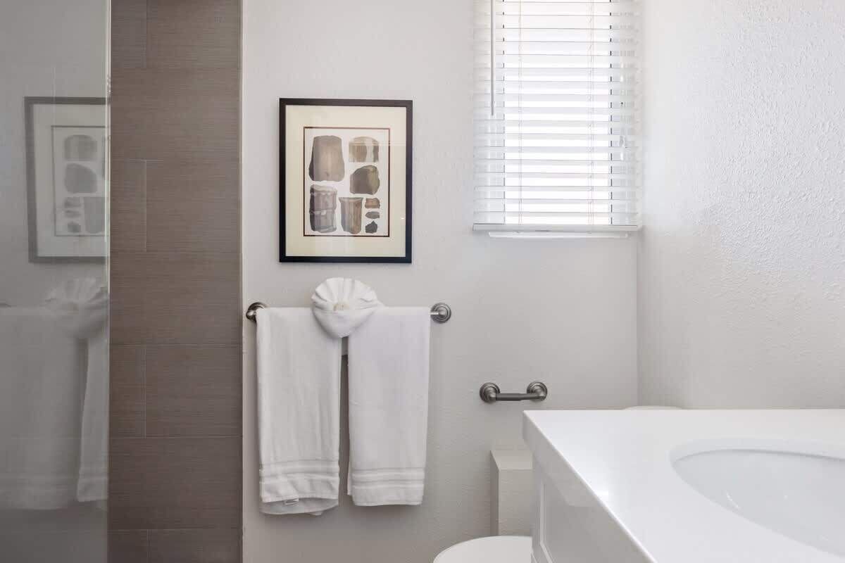 Un bagno con una vasca da bagno bianca, un water e un portascopevoli con due asciugamani.