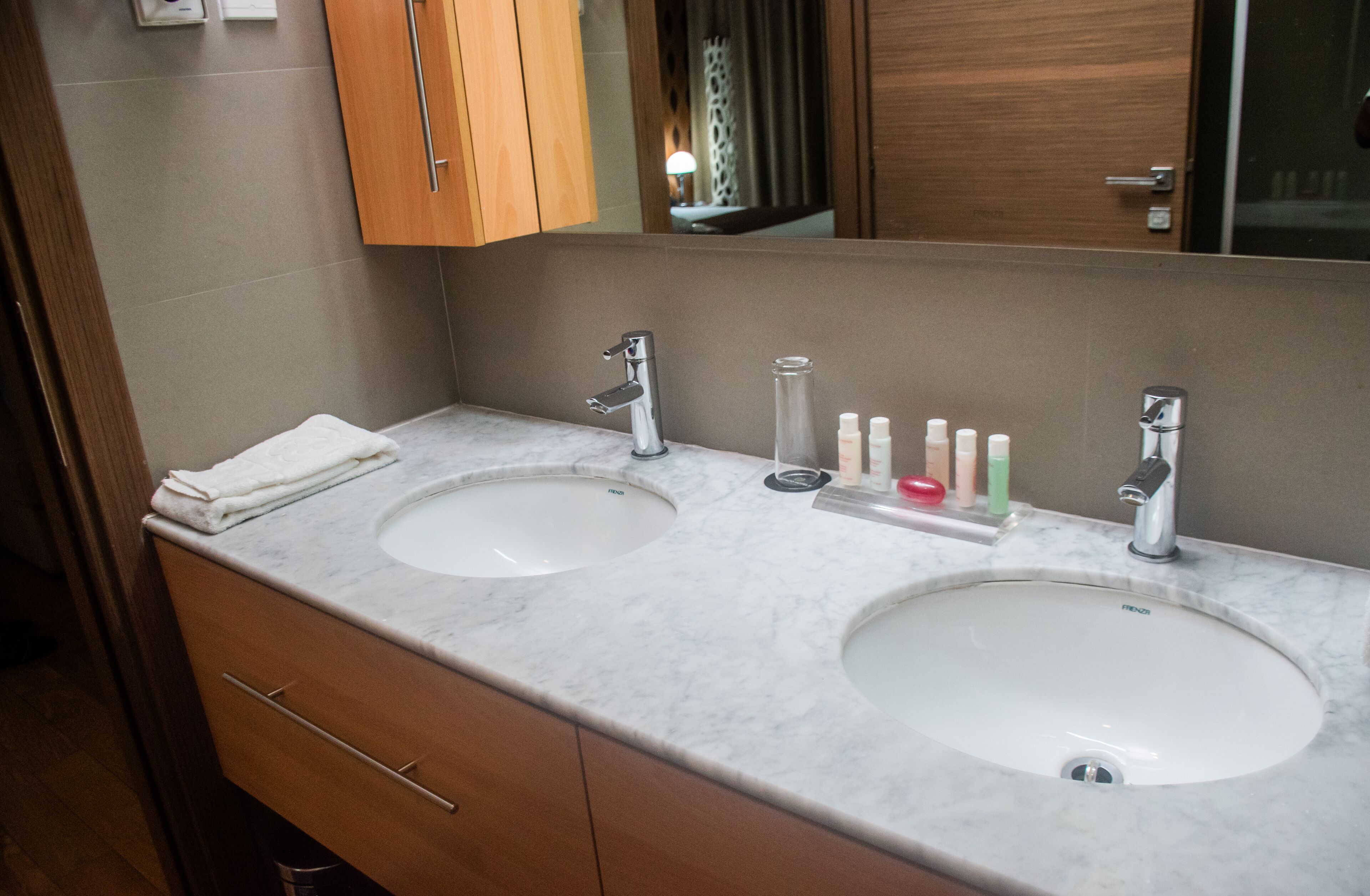 A bathroom with two sinks, wooden cabinets, and a mirror.