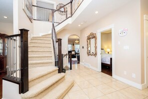 A spacious interior with a grand staircase, a large mirror, and a cozy bedroom. - Luxury home 3700 sq with jetted tub / 4 fireplaces / sleep 9 (Edmonton)