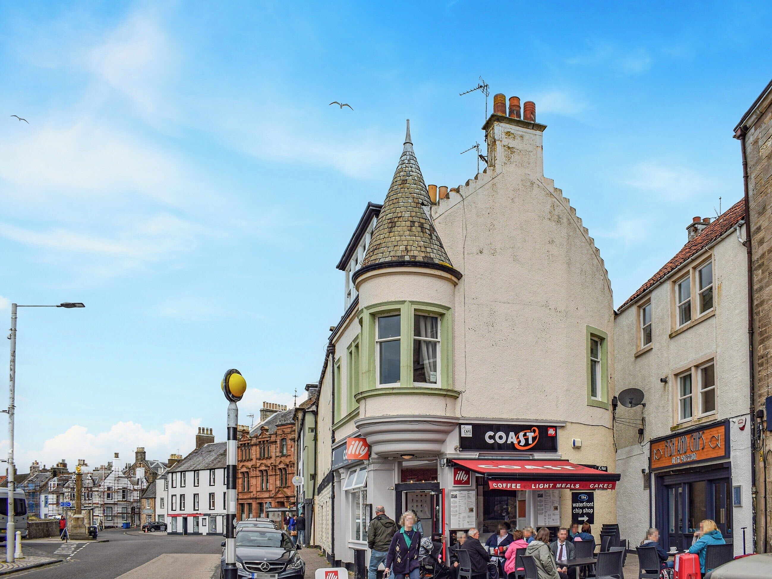 A street with a cafe named 'COAST' and another named 'Fish and Chips'.