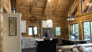 A cozy cabin interior with a kitchen, dining area, and living room. - Beautiful & Brand New Cabin in Duck Creek  (Duck Creek Village)