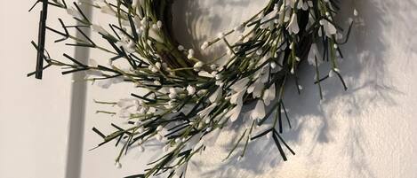 Un arreglo floral en una puerta con un letrero debajo que dice 'LOVE YOU TO THE MOUNTAINS AND BACK'.