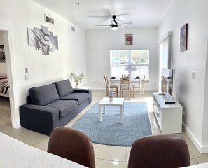 Relax in this stylish living room with a sofa, coffee table, and dining area.