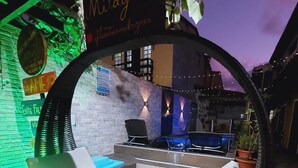 A cozy outdoor seating area with a swing chair, a pool table, and a sign reading "Mulagnes Fotomilagres." - Flats Três Milagres-Pousada (São Miguel dos Milagres)