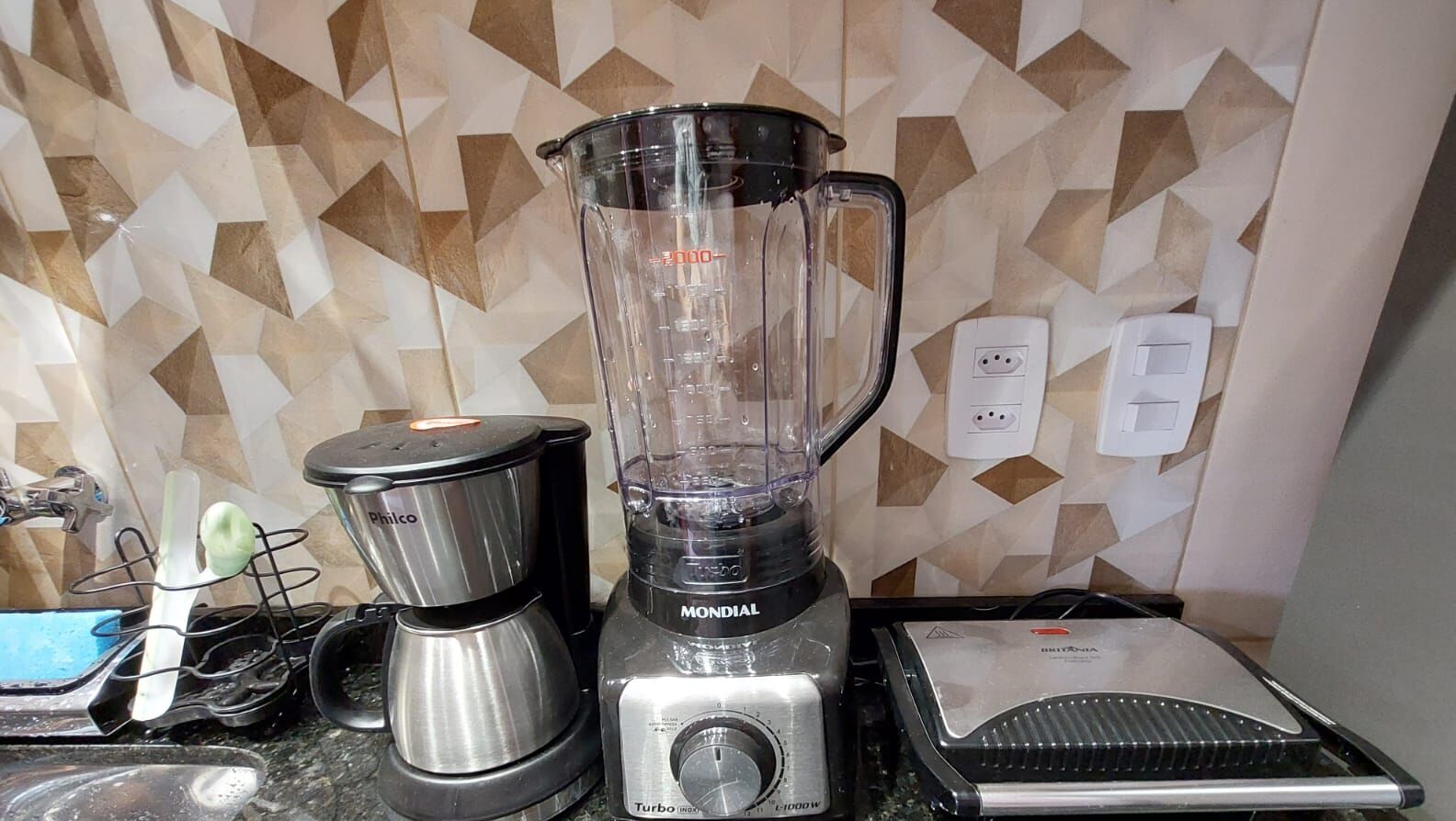 Cozinha com liquidificador, cafeteira e torradeira na bancada.