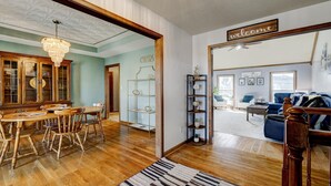 A spacious living room with a wooden dining table, chairs, and a chandelier. There is a bookshelf and a 'welcome' sign on the wall. - Kentucky holiday home with Hot Tub & pool In Louisville KY (Louisville)