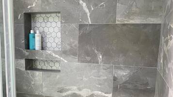 Chuveiro, secador de cabelo, toalhas de banho, papel higiênico