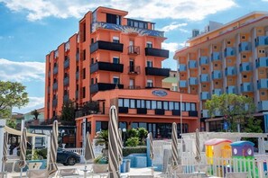 A multi-story hotel with balconies, outdoor seating, and a sign indicating it is a hotel. - Hotel Giorgetti Palace (Bellaria)
