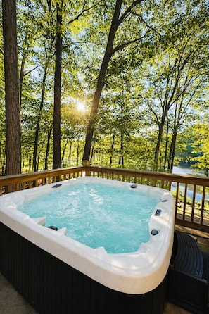 Un jacuzzi en una terraza con vistas a un bosque.