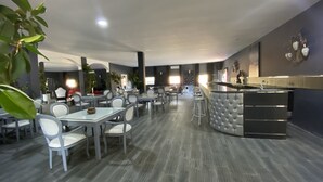 A modern restaurant with a bar area, multiple seating options, and a polished interior design.