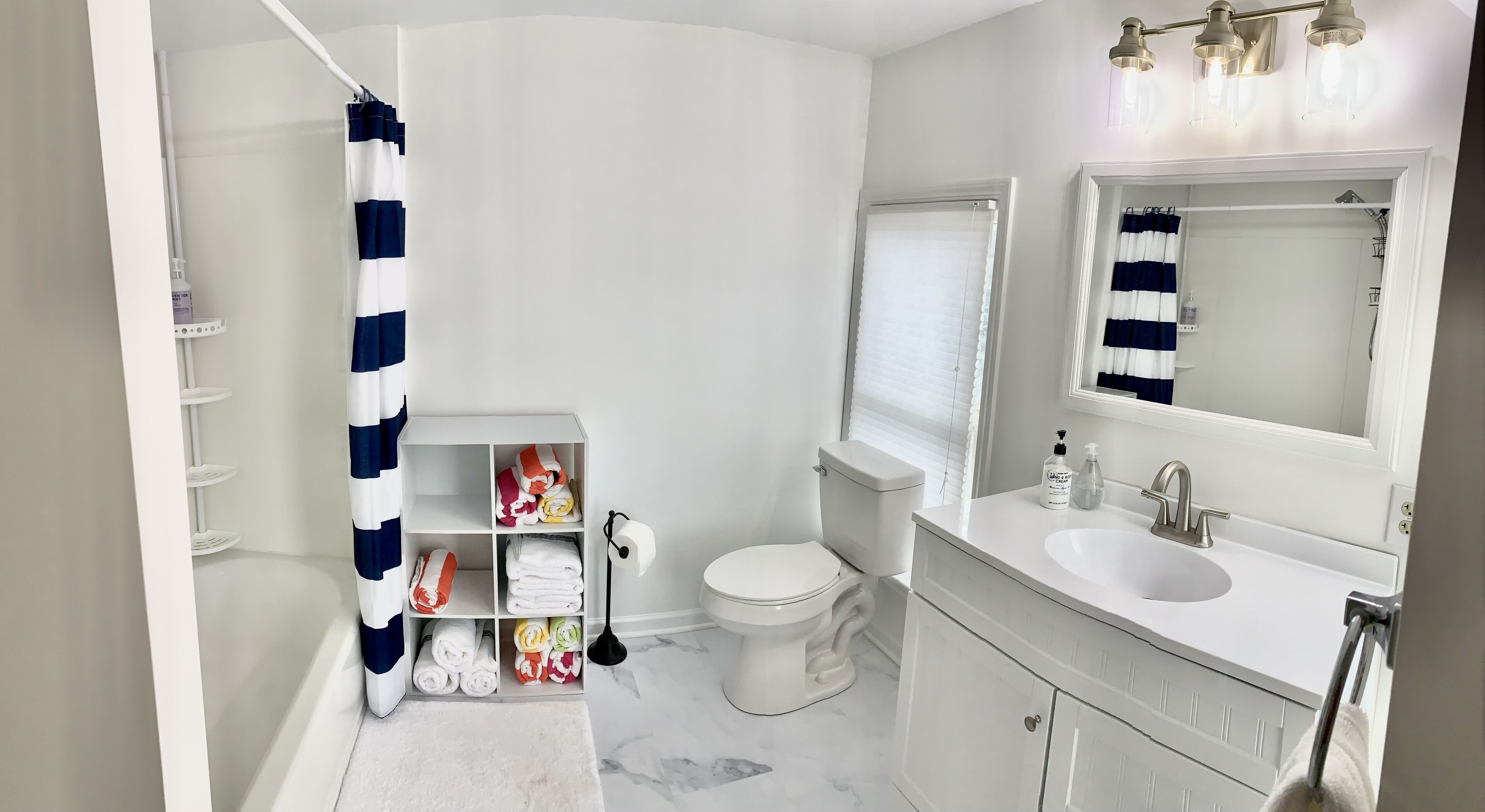 A modern bathroom with a toilet, sink, and shower curtain.