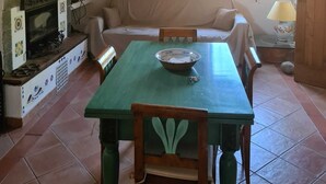 A cozy living room with a fireplace, a dining table, and a sofa. - Wonderful Villa with garden in Ansedonia (Ansedonia)