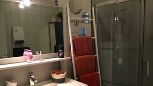 A bathroom with a sink, mirror, towel rack, and shower. - Room with private exit to small garden (Moussac)