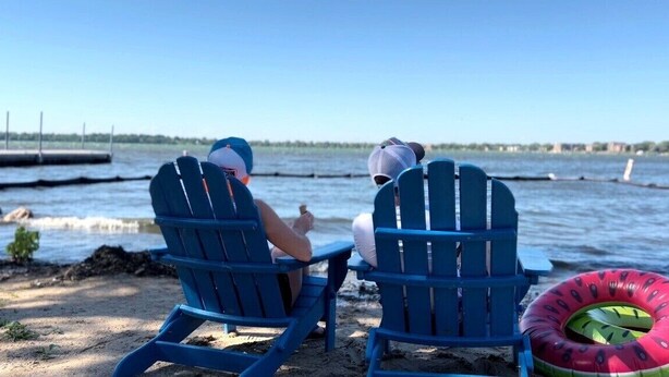 Two people sitting on blue Adirondack chairs facing a body of water with a dock in the background. - Near DT Madison - One Block from Lake Monona & Lake Loop Bike Path (Monona)
