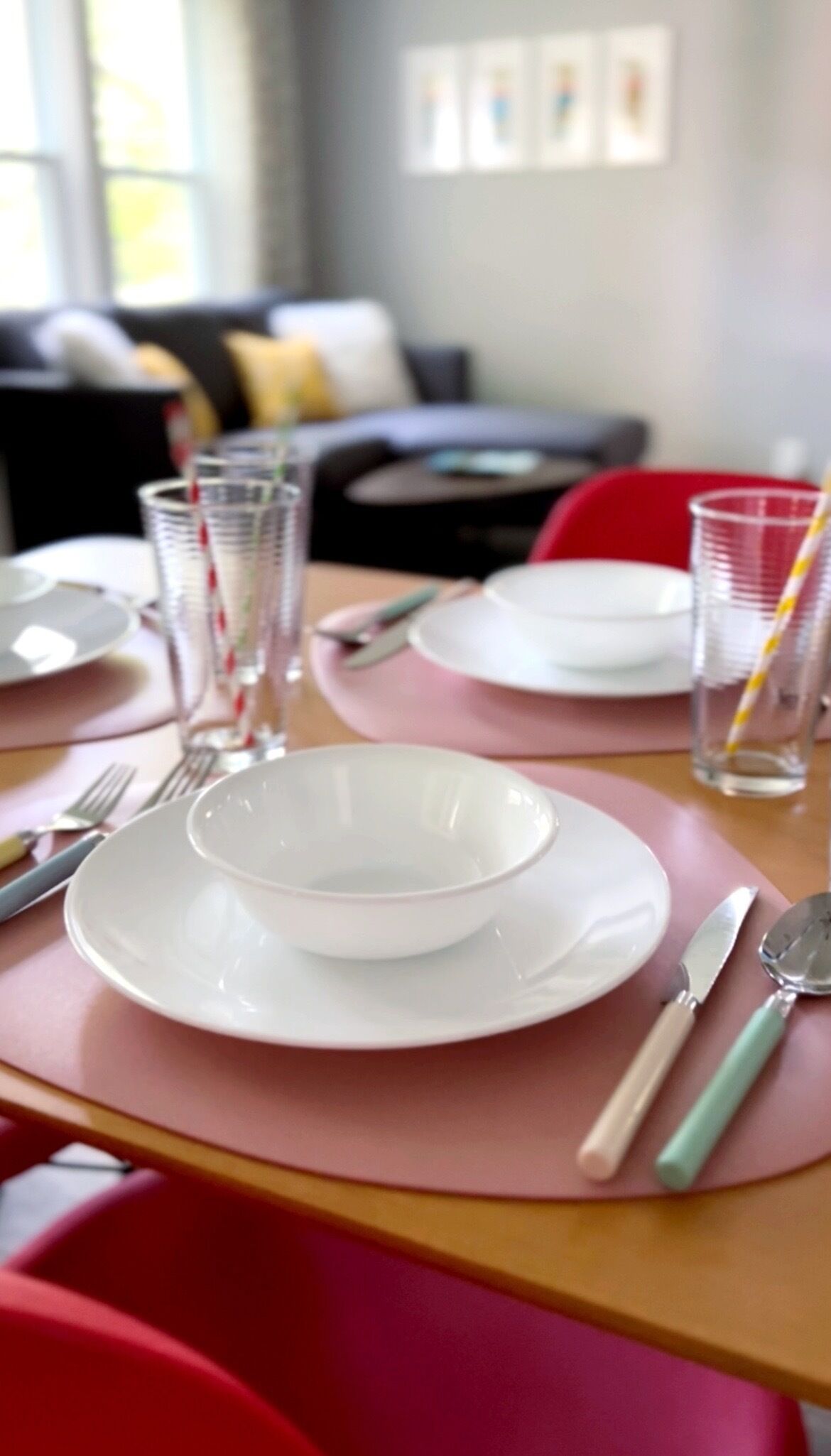 A dining table with plates, cutlery, and glasses set for a meal.