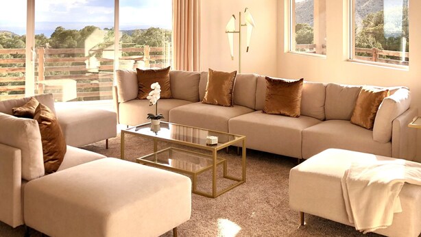 A spacious living room with a large sectional sofa, a glass coffee table, and a view of the outdoors through large windows. - Architectural Peace and Perfection in the Sandia Mountains (Albuquerque)