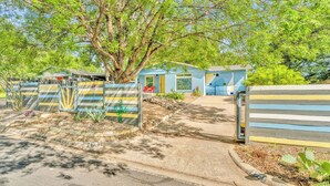 Un quartier résidentiel avec une maison bleue, un arbre et une porte.