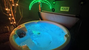 Un bain à remous orné d’une étiquette indiquant « DIXIE BEER » et d’un panneau arborant un motif de palmier.