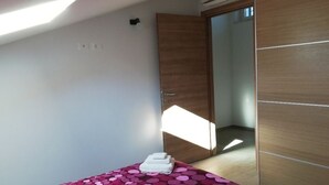 Une chambre à coucher avec un lit, une armoire et un miroir.
