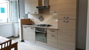 Une cuisine moderne avec des meubles en bois, une cuisinière à gaz et un four encastré.