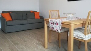Un coin repas avec une table en bois, deux chaises et un bol posé sur la table.