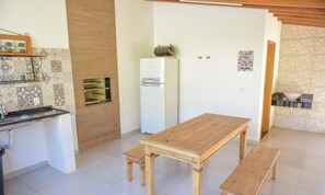 A kitchen with a wooden table, a refrigerator, and a microwave.