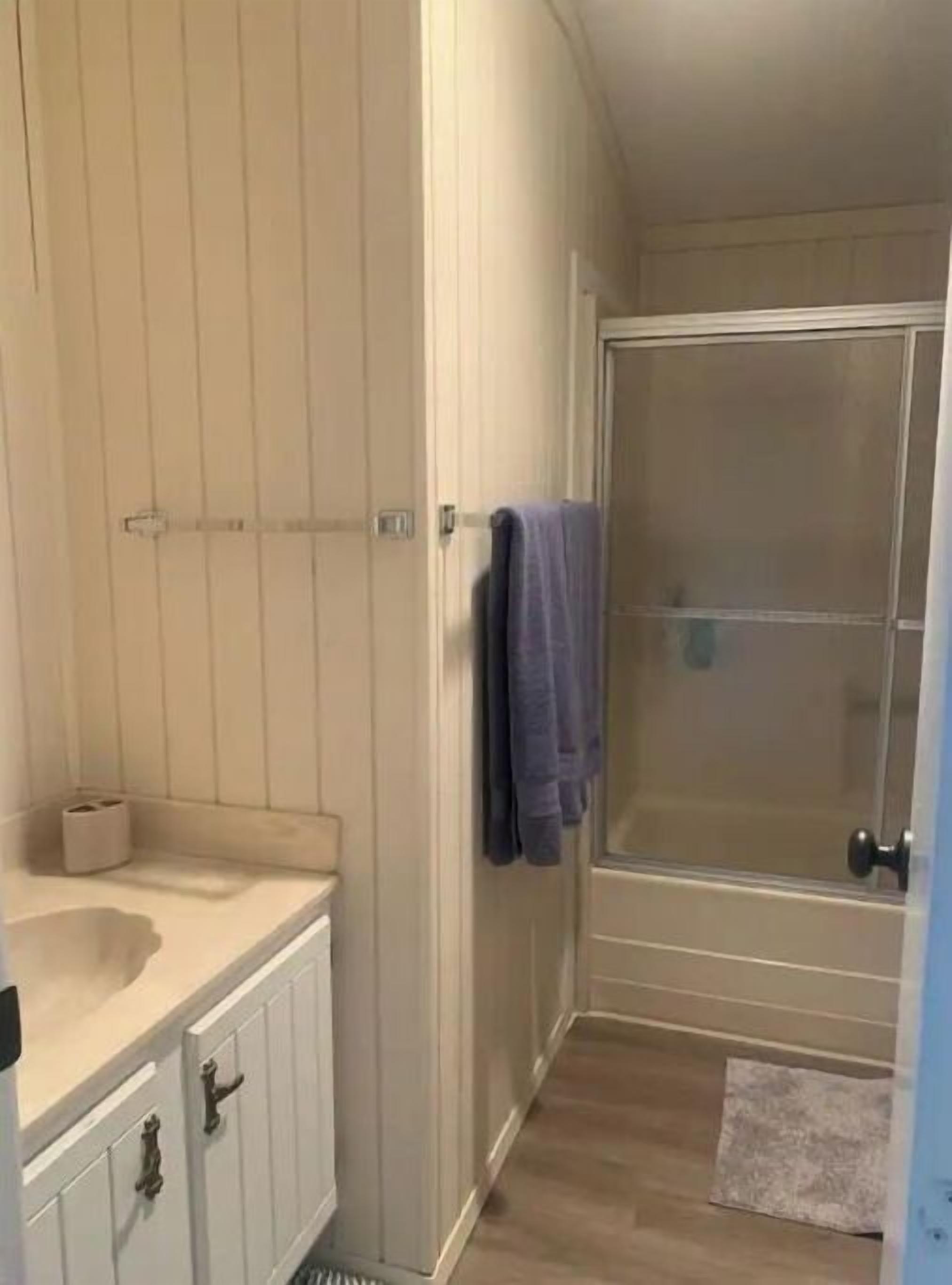 A bathroom with a sink, mirror, and towel rack.