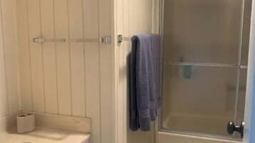 A bathroom with a sink, mirror, and towel rack.