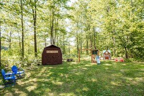 Relax by the serene boat house, surrounded by lush greenery and tranquil trees.
