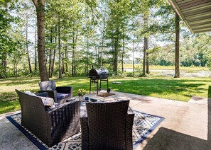 Relax and dine al fresco in this serene outdoor space, featuring a grill and comfortable seating.