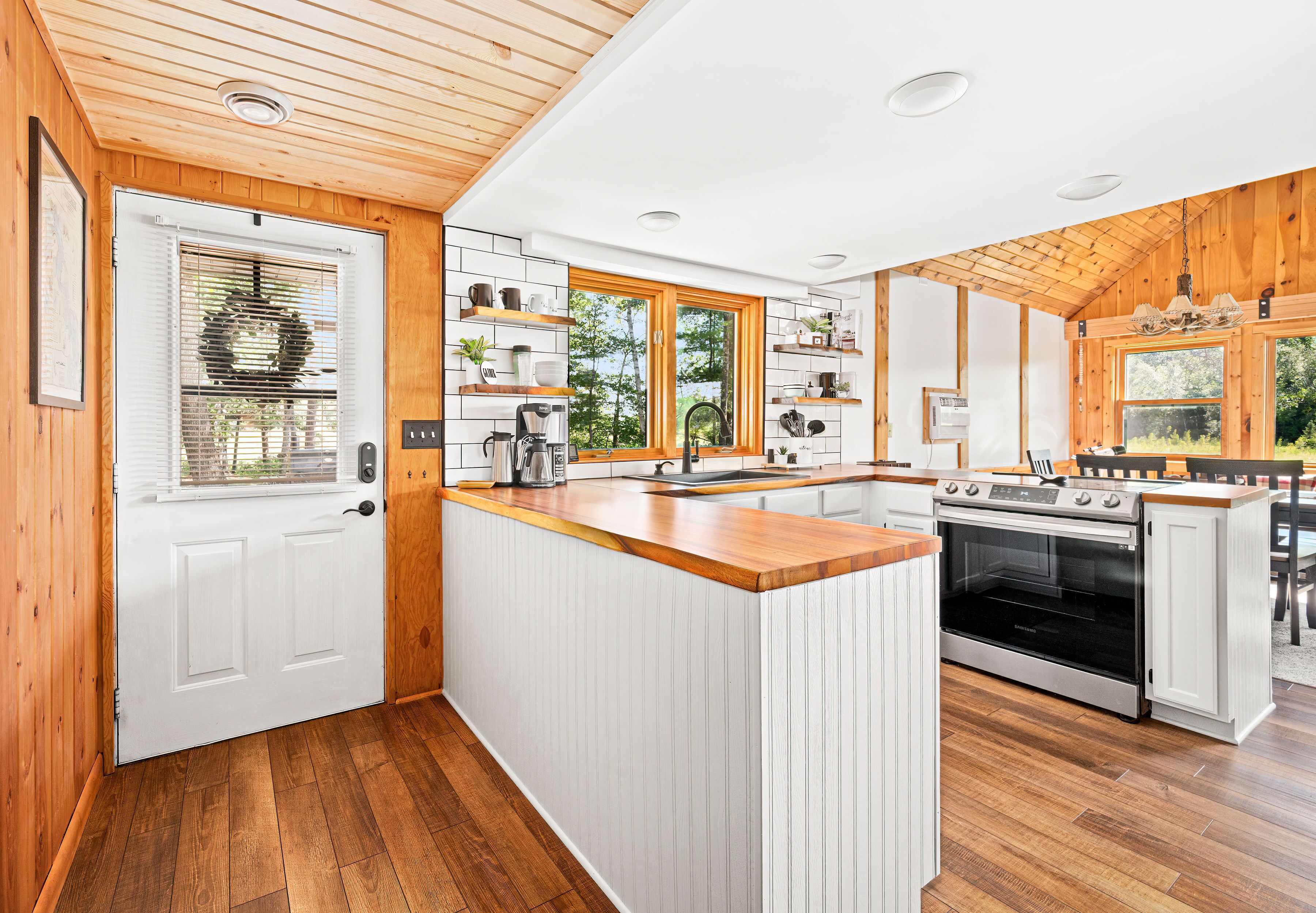 Een moderne keuken met houten details, witte kastjes en een centraal eiland.