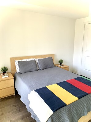 Cozy retreat with a large bed, two nightstands, and potted plants.