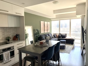 Enjoy a spacious living area with a sofa set and dining table, perfect for entertaining. The kitchen features contemporary appliances and ample counter space.