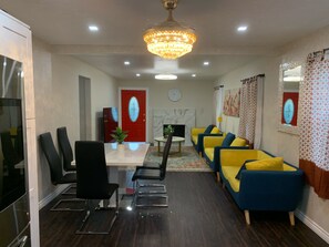 A dining area with a table, chairs, and a chandelier.
